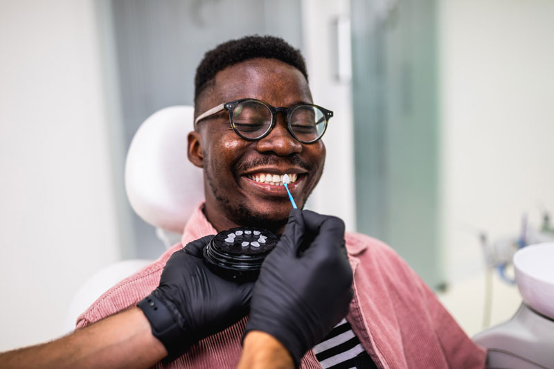 a dental patient smiling during a porcelain veneers procedure.