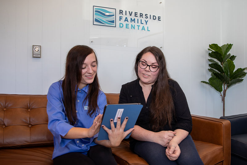 staff member going over dental treatment information with patient within the dental center